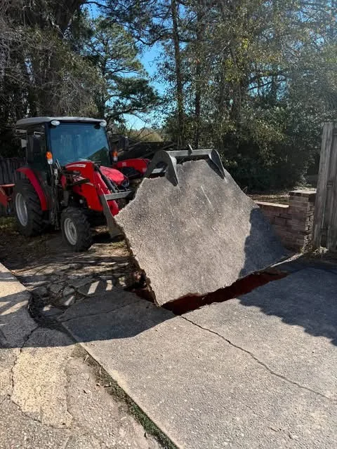 Tractor lifting a section of old concrete